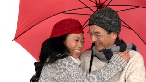 Couple-with-an-umbrella-hugging-
