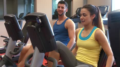 Couple-using-exercise-bikes-in-gym