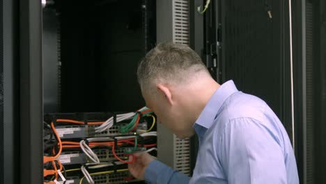 Techniker-Schaut-Auf-Offenen-Serverschrank