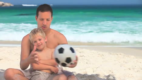Vater-Und-Kleiner-Sohn-Spielen-Mit-Einem-Ball-Am-Strand