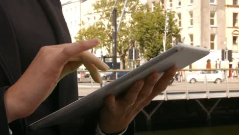 Businesswoman-using-her-tablet-outside
