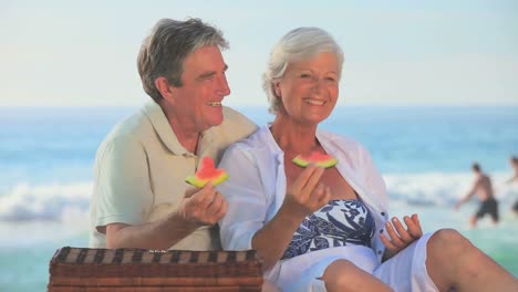 Mature-couple-eating-picnicking-on-a-beach