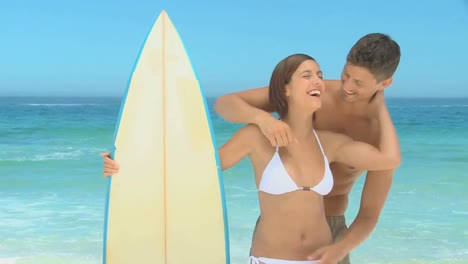 Cute-couple-holding-a-surfboard