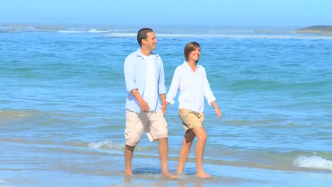 Happy-couple-walking-on-a-beach