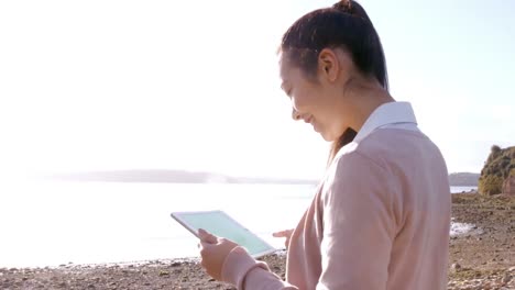 Businesswoman-using-tablet-on-the-beach