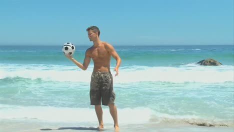 Handsome-darkhaired-man-playing-with-a-soccer-ball-