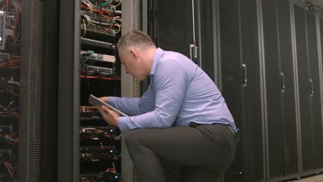Technician-using-tablet-pc-while-analysing-server