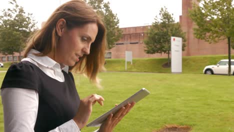 Businesswoman-using-tablet-outside