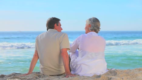 Älteres-Paar-Entspannt-Am-Strand-Sitzend