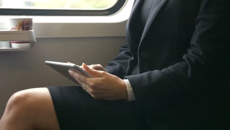 Businesswoman-using-her-tablet-on-the-train