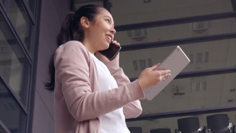 Asiatische-Geschäftsfrau,-Die-Draußen-Ihr-Telefon-Und-Tablet-Benutzt