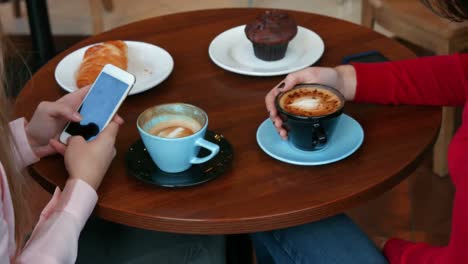 Pretty-friends-enjoying-coffee-in-cafe