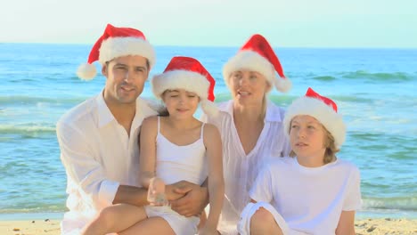 Glückliche-Familie-Mit-Weihnachtsmützen-Am-Strand