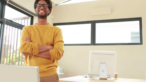 Smiling-hipster-man-standing-near-his-desk