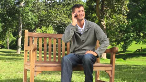 Young-man-phoning-on-a-park-bench