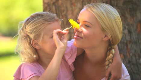 Young-girl-and-her-mother-playing-with-a-flower