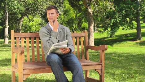 Young-man-doing-a-crossword-on-a-bench