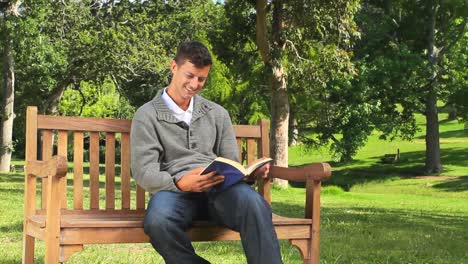 Young-man-reading-a-book-outside