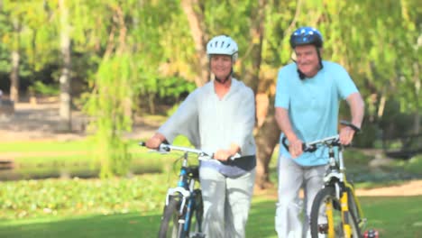 Mature-couple-walking-with-their-bikes