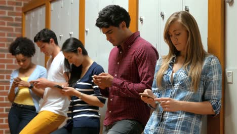 Students-leaning-against-lockers-using-smartphones