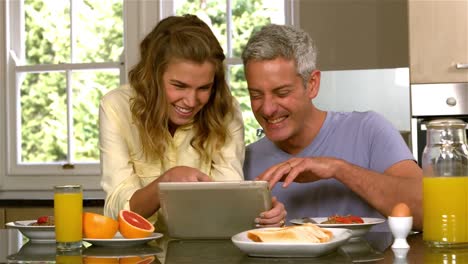Glückliches-Paar,-Das-Tablet-In-Der-Küche-Benutzt