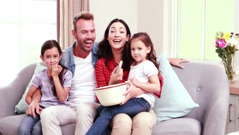 Happy-family-with-popcorn-on-sofa-