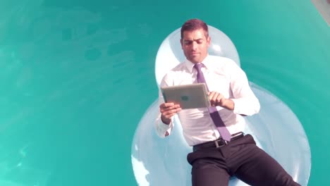 Businessman-using-tablet-pc-on-inflatable
