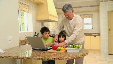 Man-teaching-his-grandchildren-how-to-cook-