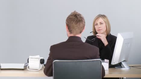 Two-associates-talking-at-a-desk