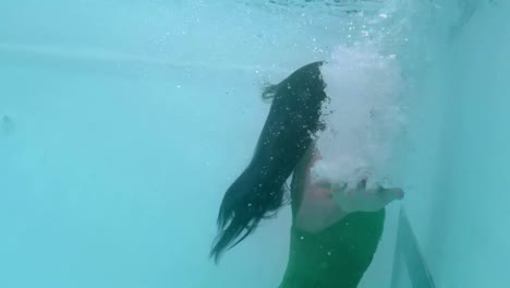 Schöne-Frau-Mit-Grünem-Kleid,-Die-Unter-Wasser-Schwimmt