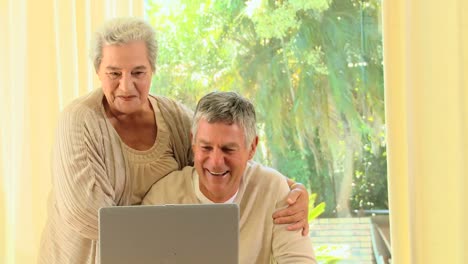 Älteres-Ehepaar-Lacht-über-Etwas-Auf-Einem-Laptop