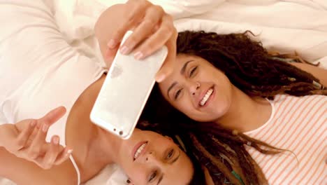 Glückliches-Lesbisches-Paar-Auf-Dem-Bett,-Das-Selfie-Macht