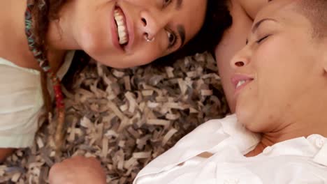 Happy-lesbian-couple-laying-on-carpet