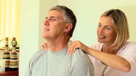 Woman-massaging-her-husbands-shoulders