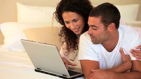 Young-couple-laughing-at-something-on-their-laptop-