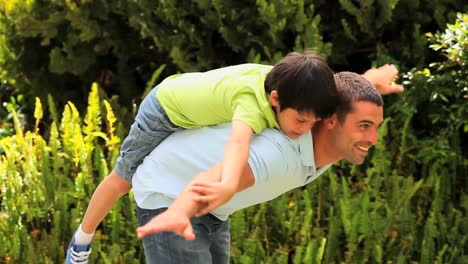 Father-with-his-son-on-his-back-playing-in-the-garden