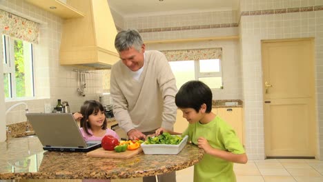 Man-teaching-his-grandchildren-to-cook