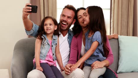 Happy-family-taking-selfie-on-sofa