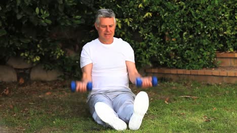 Man-exercising-his-arms-using-dumbbells