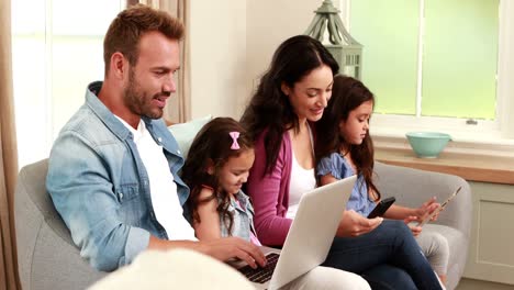 Glückliche-Familie,-Die-Geräte-Auf-Dem-Sofa-Benutzt