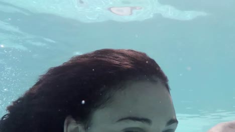 Hübsche-Frau-Schwimmt-Unter-Wasser-Im-Pool