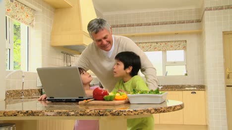 Children-gathering-ingredients-for-a-recipe-they-have-on-a-laptop