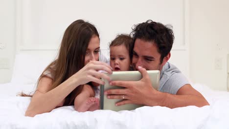 Liebevolle-Eltern-Mit-Ihrer-Kleinen-Tochter,-Die-Ein-Tablet-Nutzt