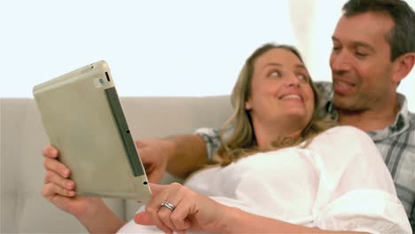 Happy-future-parents-using-tablet