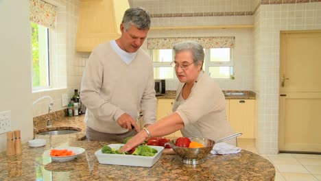 Mature-couple-preparing-vegetables