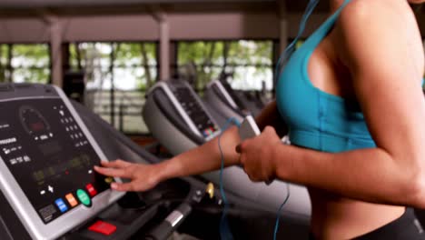 Smiling-muscular-woman-running-on-treadmill
