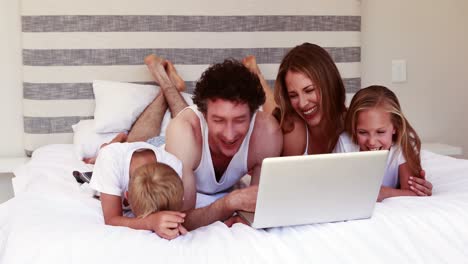 Glückliche-Familie-Mit-Laptop-Im-Bett