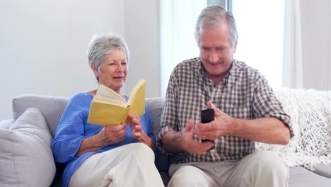 Cute-elderly-couple-reading-or-watching-TV