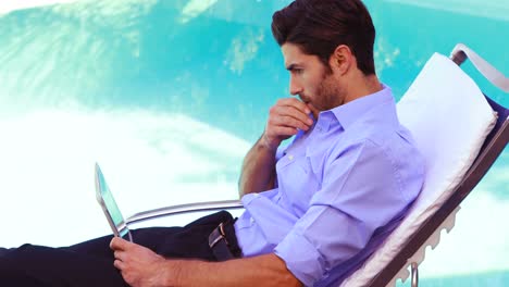 Handsome-man-using-tablet-on-deck-chair