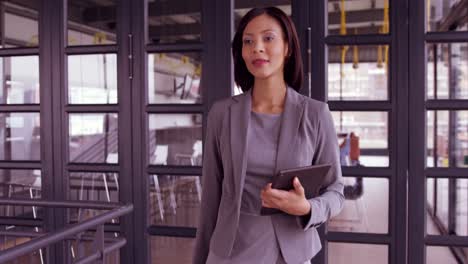 Businesswoman-walking-with-tablet-
